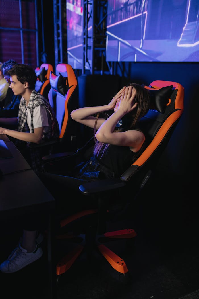 why-choose-us Woman covering eyes in gaming chair at esports event, expressing frustration after a loss.